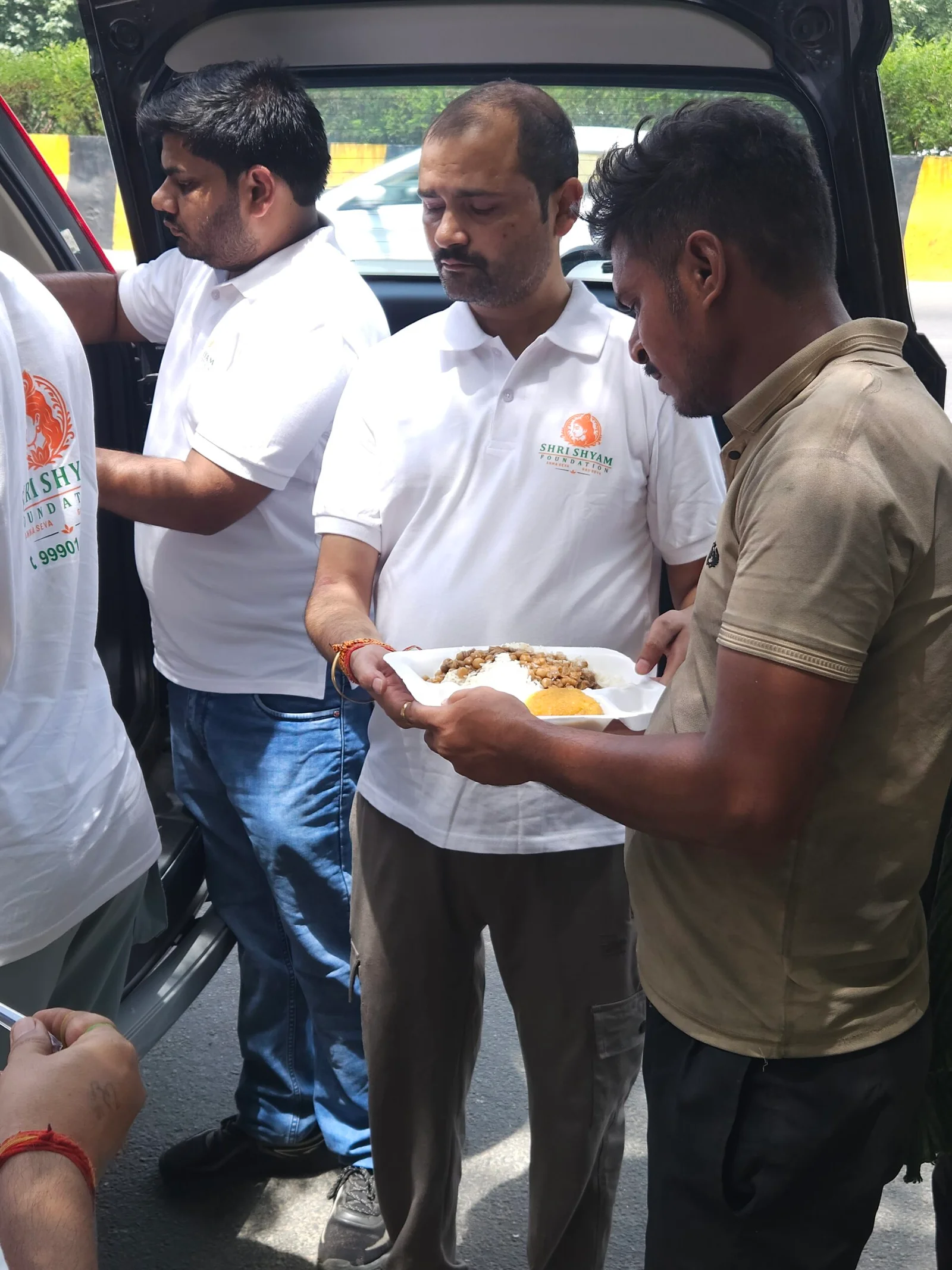 People queuing for hot meals served from large community pots